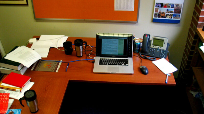 An employee working on a laptop in an office